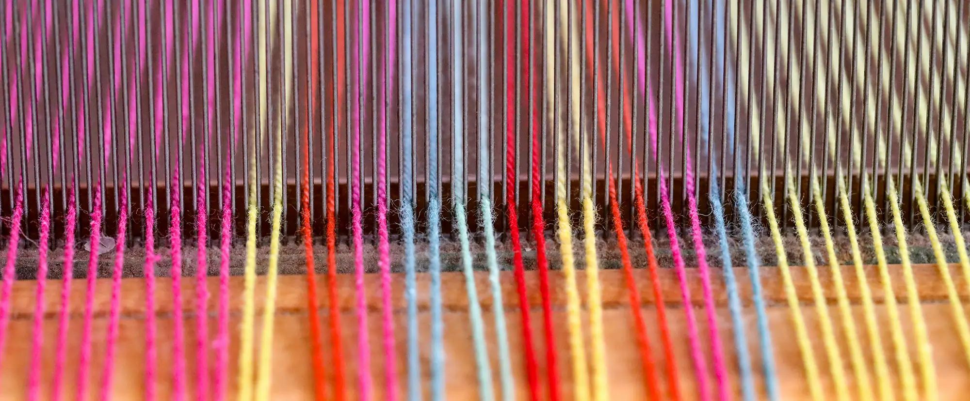Photograph of multiple coloured wollen threads on a sewing machine